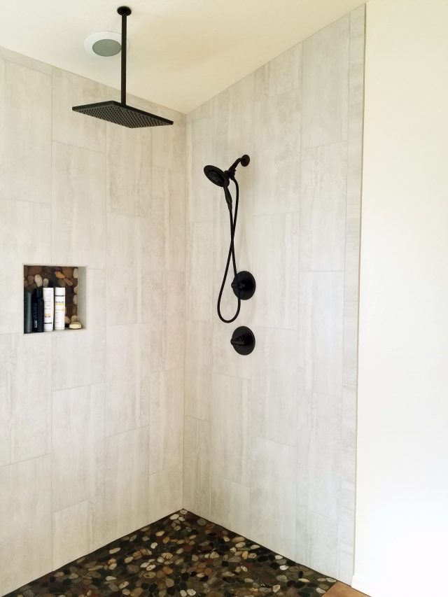 bathoom remodel with river rock base and waterfall shower head