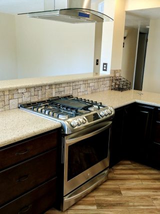 kitchen remodel with stone backsplash and wood flooring