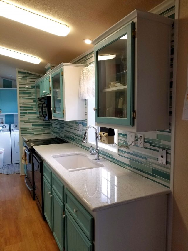 teal kitchen remodel with glass backsplash to ceiling